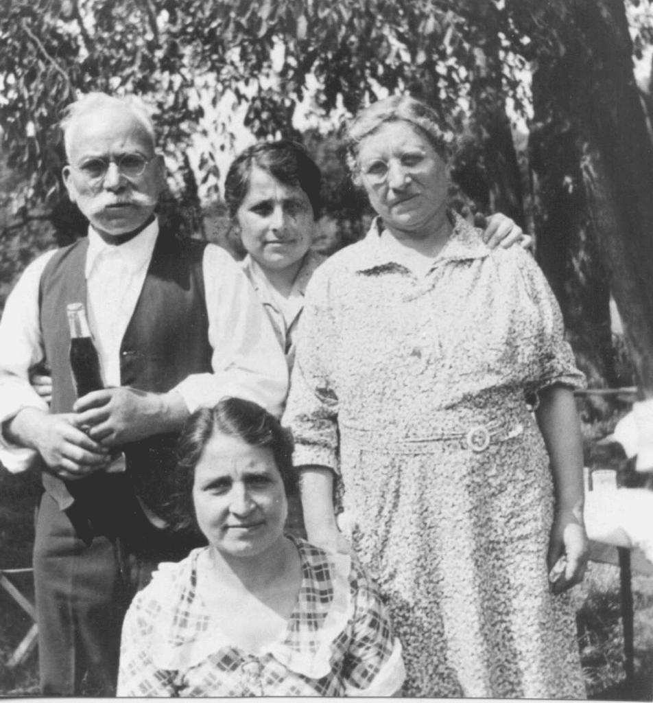 Black and white family photo showing two grown daughters and their parents. 