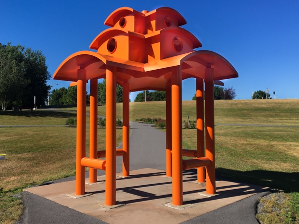 Outdoor sculpture that resembles a bright orange pagoda.