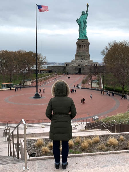The author seen from behind, looking down the brick plaza at the back side of the Statue of Liberty.
