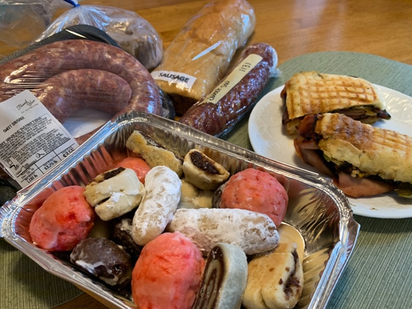 Assortment of Italian specialty foods: cookies, sausage, and Italian sausage roll. 