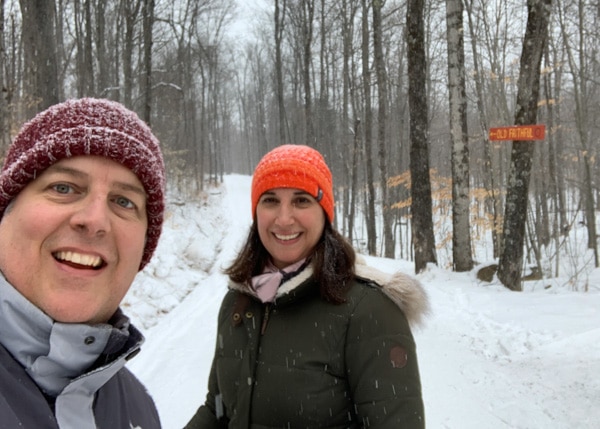 A man and a woman on a snowy cross-country ski trail.
