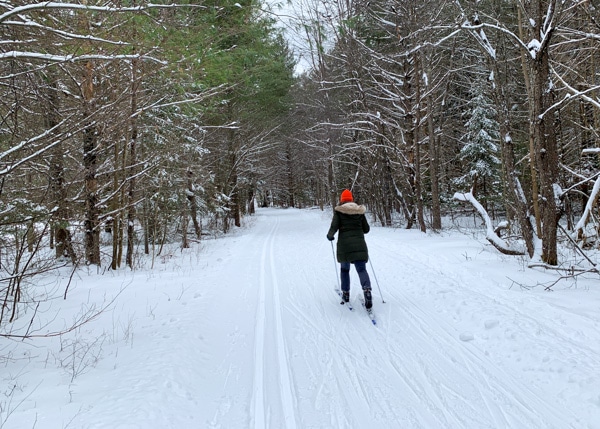 Person seen from behind cross-country skiing.