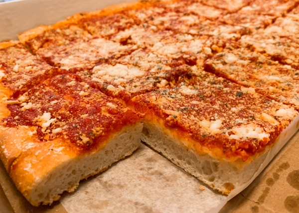 Close-up of a whole tomato pie with one slice missing. 