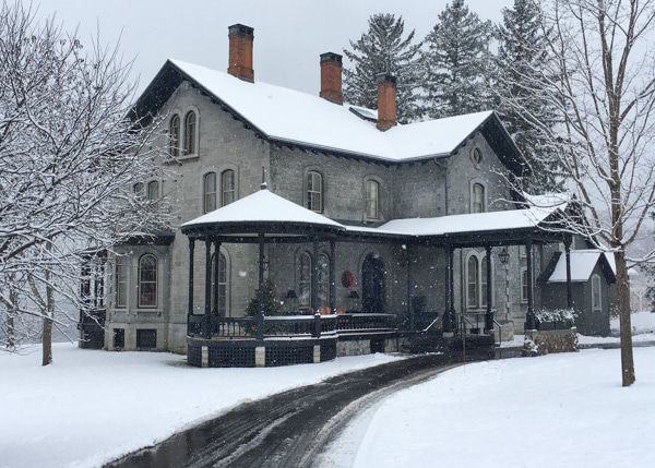 E.B. Morgan House exterior on a snowy day. A two-story gray brick home with a gazebo on the porch. T