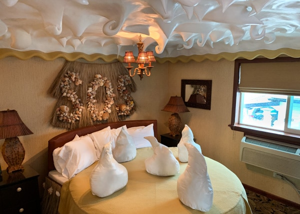 Coconut cream pie-themed hotel room. The bed is round and the bed pillow and ceiling are in the shape of whipped cream peaks.