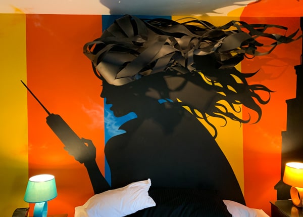 Silhouette of a woman's wild hair flying behind her. She is holding a telephone. Resembles a profile of Farrah Fawcett in "Charlie's Angels."
