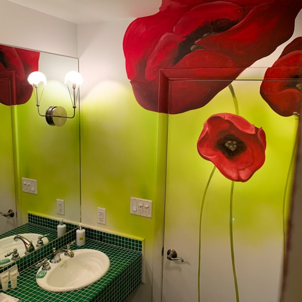 Giant red poppies painted on the bathroom wall of hotel room.