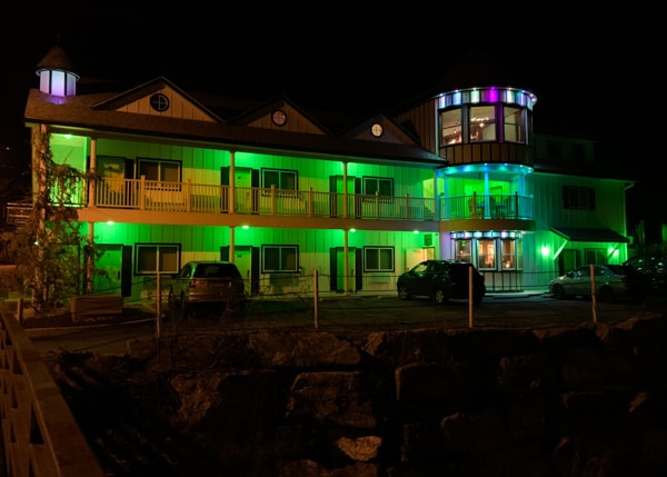 The Roxbury Motel at night, lit up in green light. 
