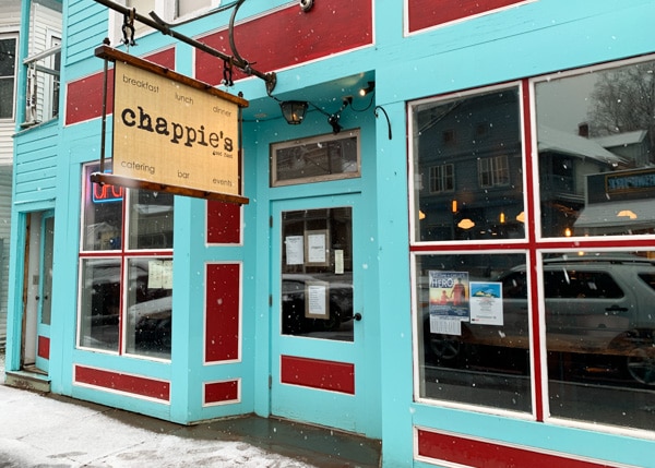 Exterior of Chappie's Restaurant. The building is painted aqua with red trim. A sign hanging above the front door says "chappie's"