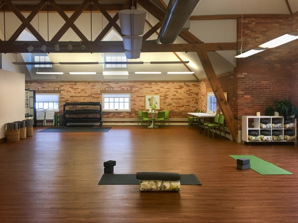 Fitness center inside Schoolhouse loft. Two yoga mats are lying on a smooth wood floor.