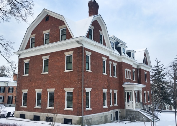 Wallcourt Hall. A three-story brick mansion. The windows and roof are trimmed in white. 