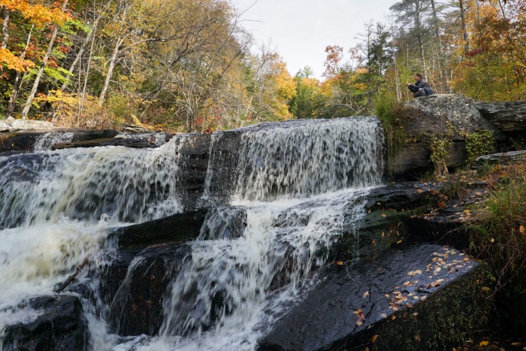 Small, cascading waterfalls with a backdrop of colorful fall foliage.
