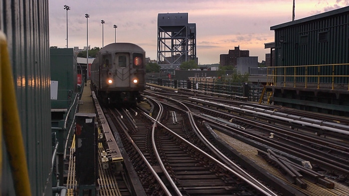 Front view of the 1 train on elevated tracks.