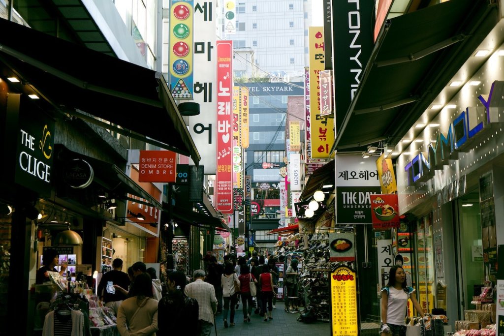 Narrow shopping street in Seoul busy with shoppers.