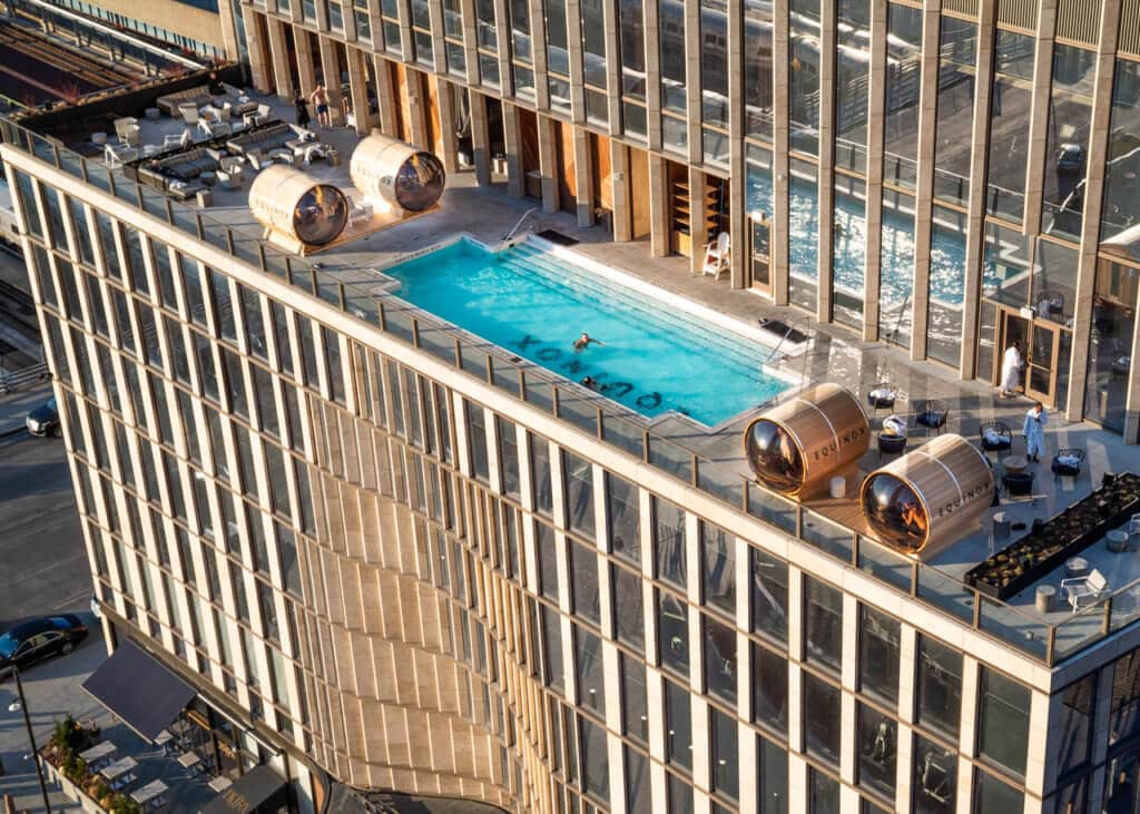View from above of rooftop swimming pool and four individual saunas. 