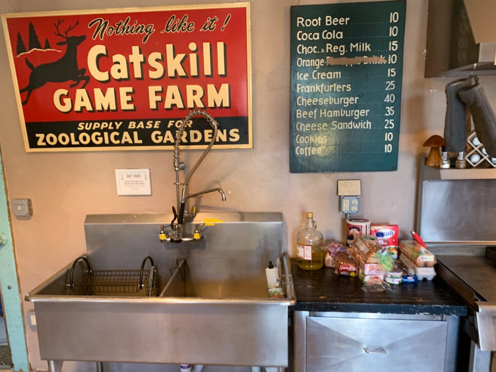 Large stainless steel sink with old-fashioned signs hanging above it.