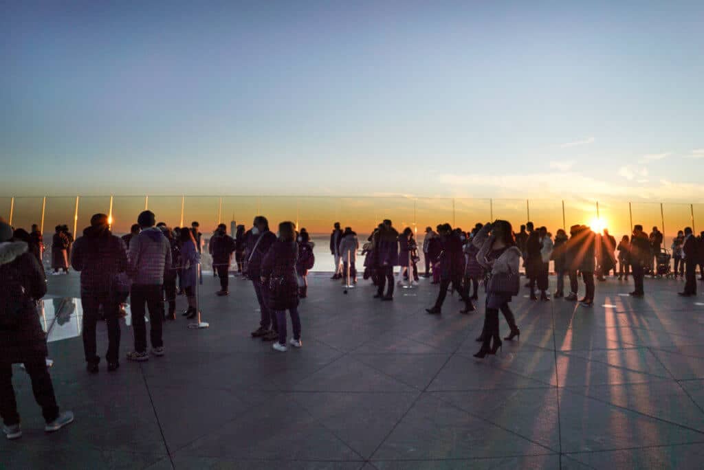 Tourists on the sky deck at Edge, looking out at the Manhattan skyline.