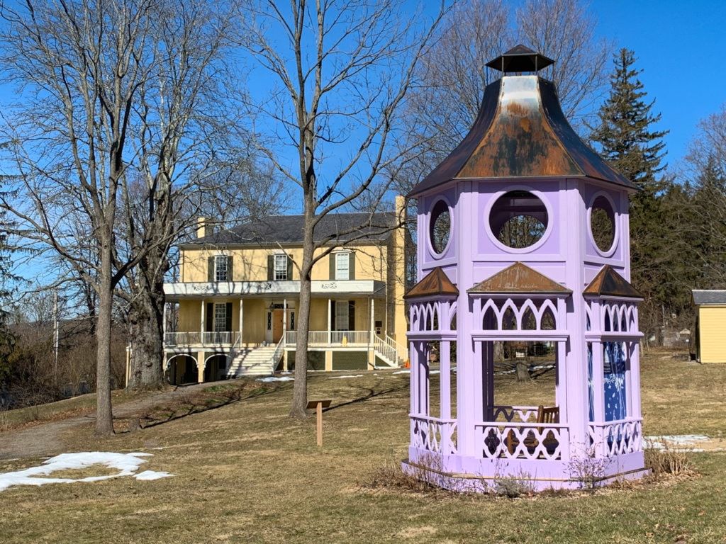 Purple octagonal building with the Main House in the background at Thomas Cole Historic Site.