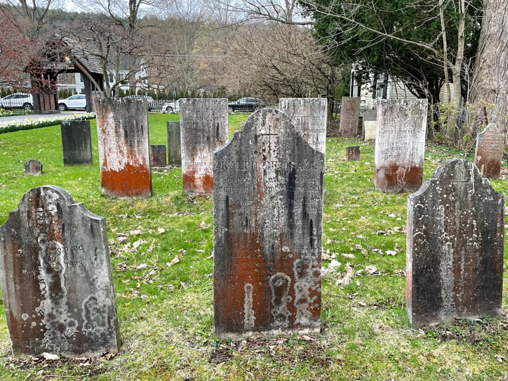 Several rows of discolored old gravestones.
