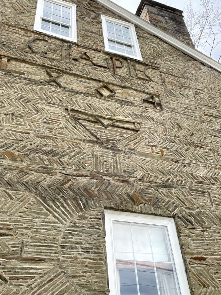 Close-up of stone house. Initials GAPC and the date, 1804, are carved into the stone.