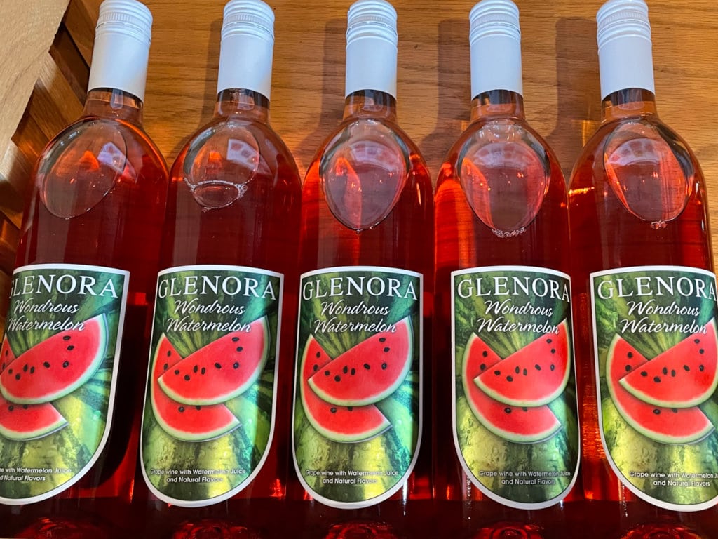 Row of five bottles of red wine, all labeled, Glenora Wondrous Watermelon. 