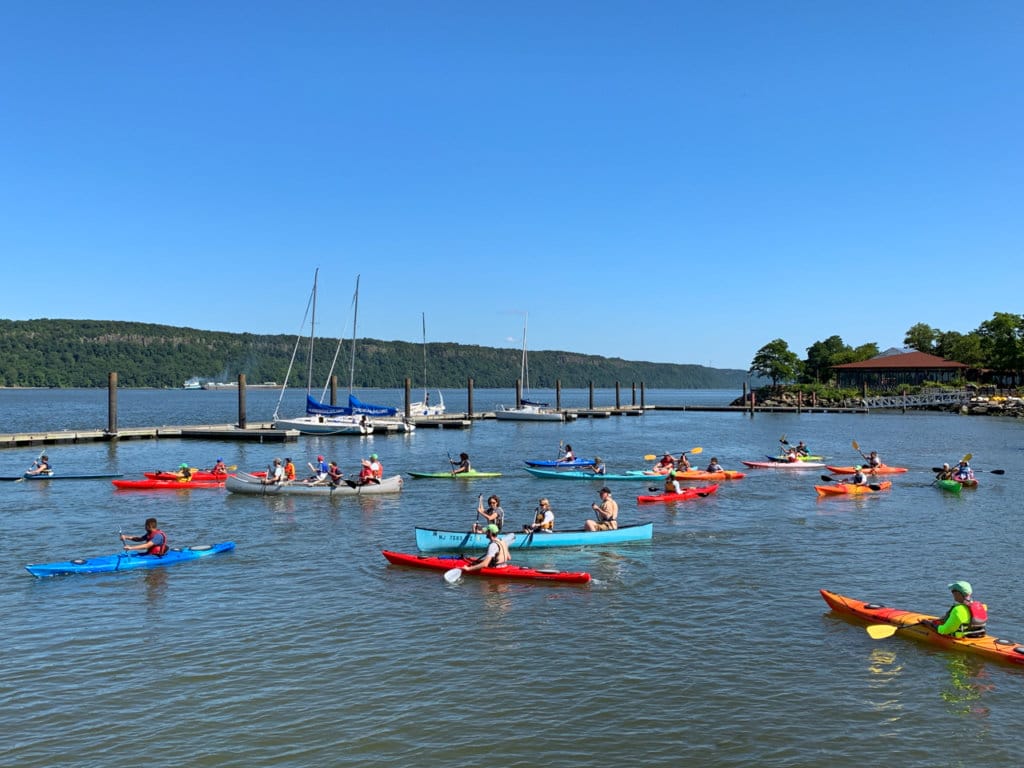 About a dozen people kayaking on the Hudson River. 
