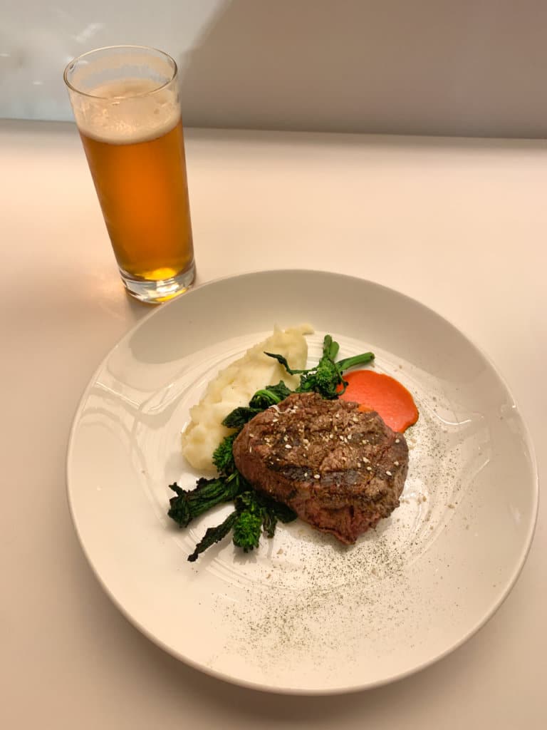 Restaurant meal: beef tenderloin on top of mashed potatoes.