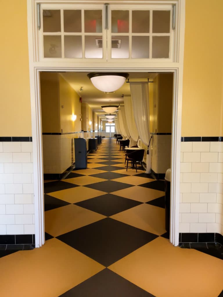 A long hallway with black and white checkered floor at Roosevelt Baths & Spa in Saratoga Springs, NY.
