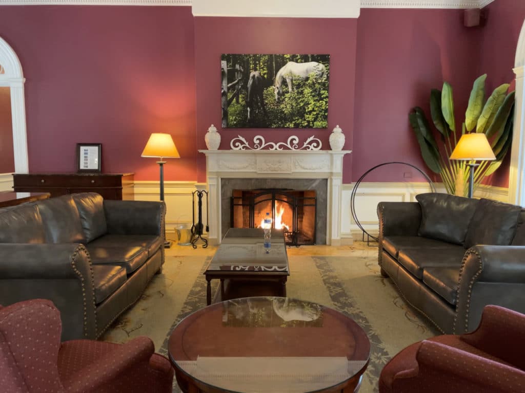 A fireplace and leather sofas in the lobby of the Gideon Putnam in Saratoga Springs, NY.