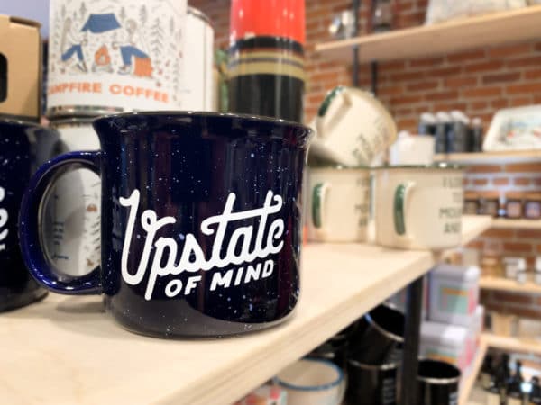Camping mug on a store shelf that says Upstate of Mind