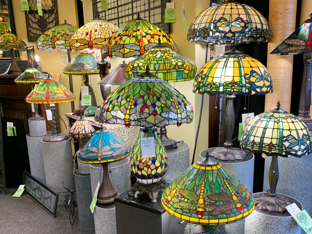 Rows of table lamps with colorful stained-glass lampshades.