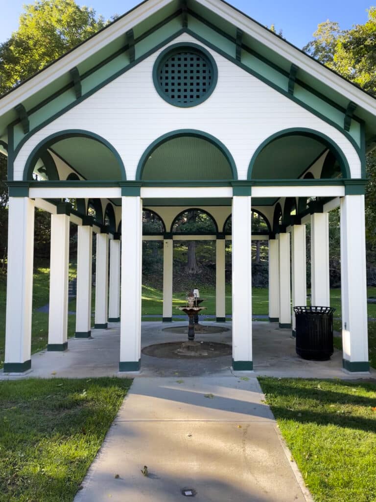 A green and white, house-like structure over a natural mineral spring fountain in Saratoga Springs, NY. 