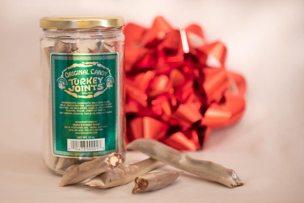 Turkey Joints candy in a glass jar with a green and sliver label. 