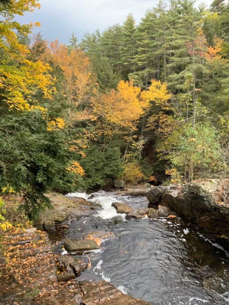 Waterfall on a hiking trail during fall foliage season. 