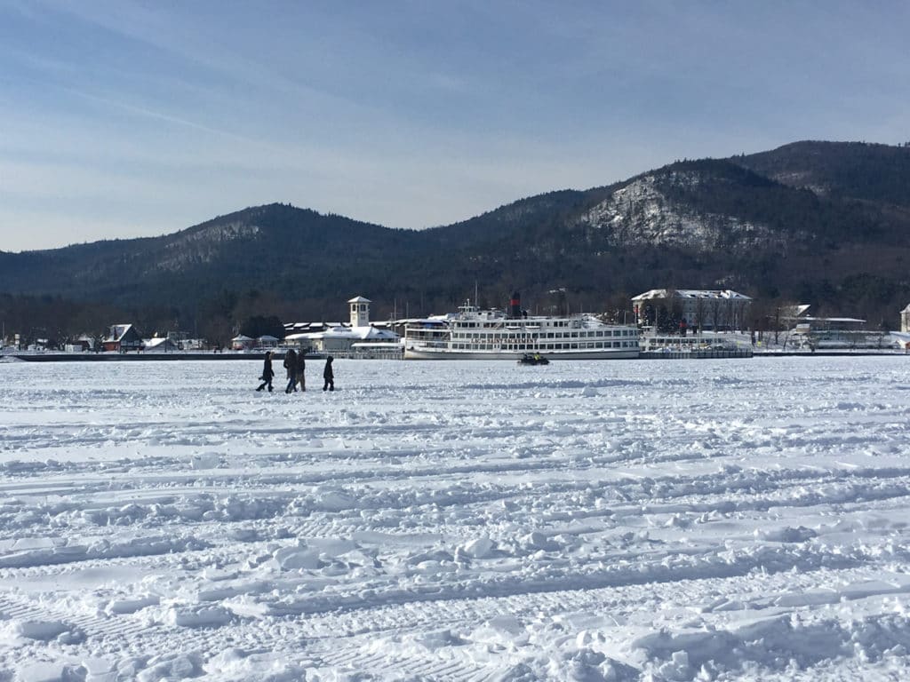 People walking in the distance over a snow-covered frozen lake. 