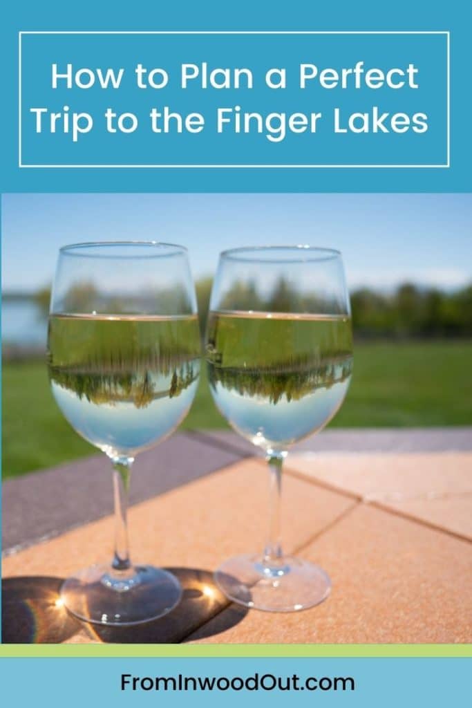 Two glasses of white wine on an outdoor table. Text overlay says How to Plan a Perfect Trip to the Finger Lakes. 