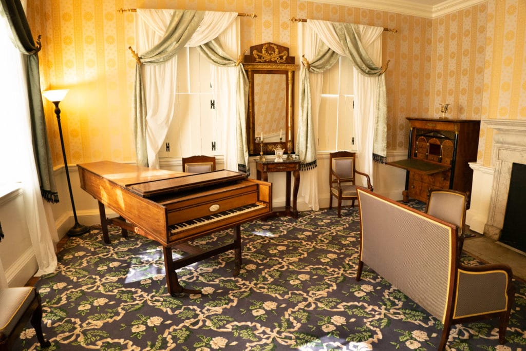 The French Parlor in Morris-Jumel Mansion furnished with an antique pianoforte, furniture, dresser, and mirrors. 