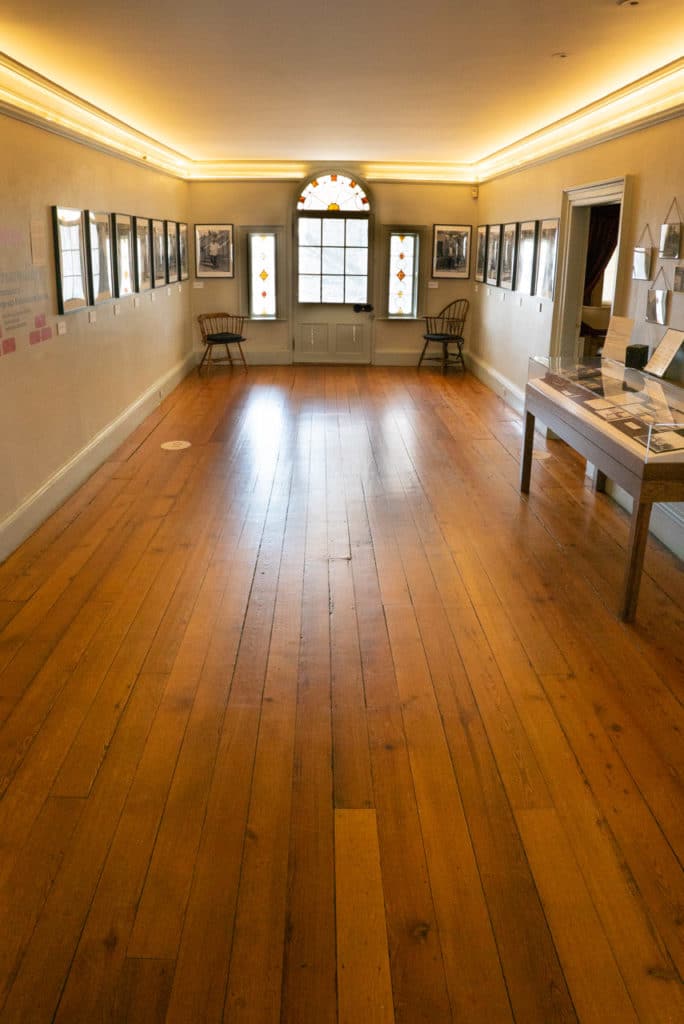 Hallway with hard-wood floors leading.