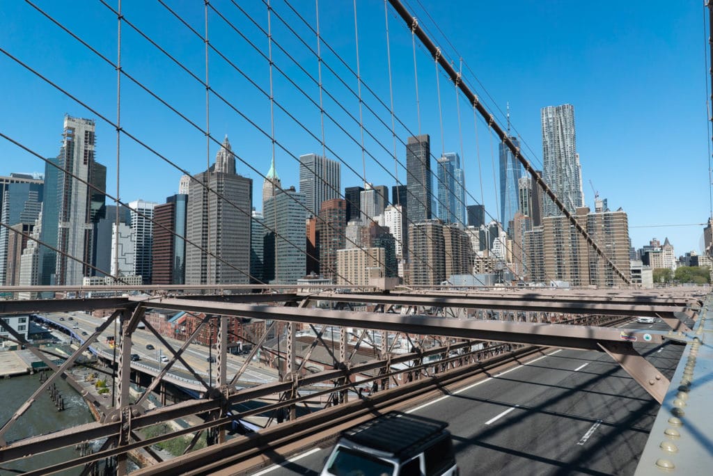 Manhattan skyline view seen through the steel cables of the Brooklyn Bridge. 