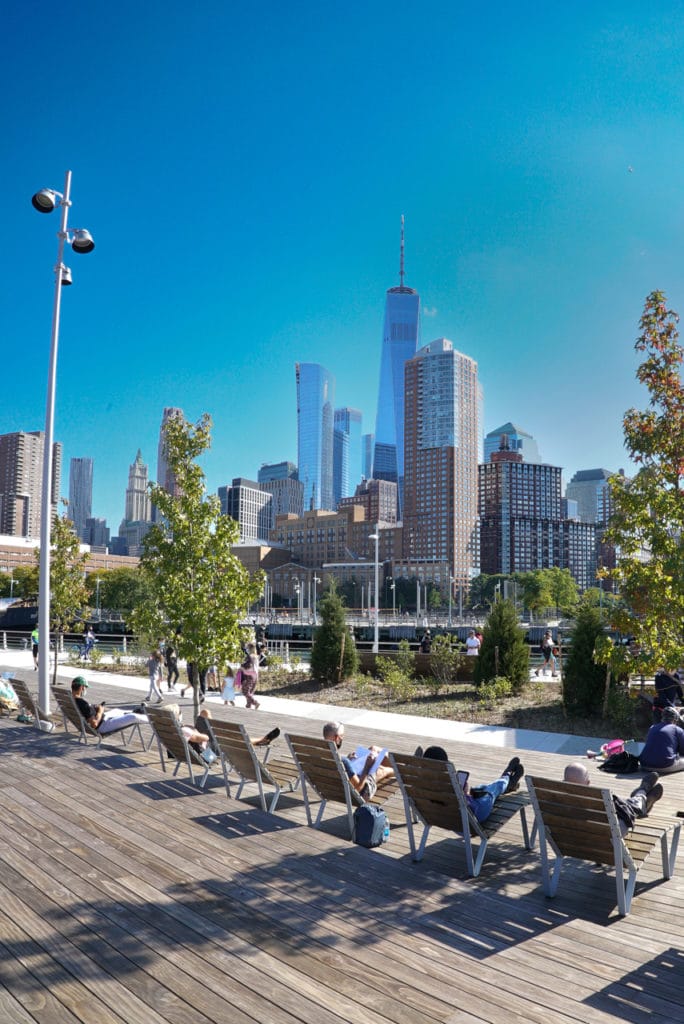 Wood chaise lounges at Pier 26, facing the skyline and One World Trade in New York City.