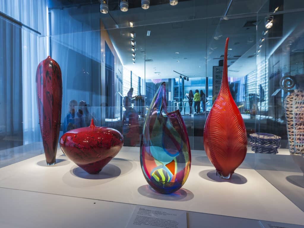 A display case showing four red vases at the Corning Museum of Glass in Corning, NY.