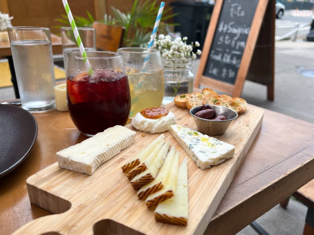 Cheese board and sangrias on an outdoor table at a restaurant in New York City.