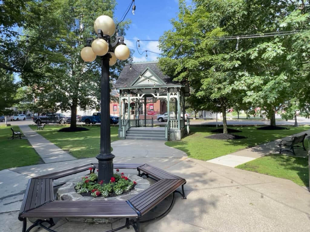 A lamppost with five large round bulbs in front of a bandstand in Hammondsport, NY. 