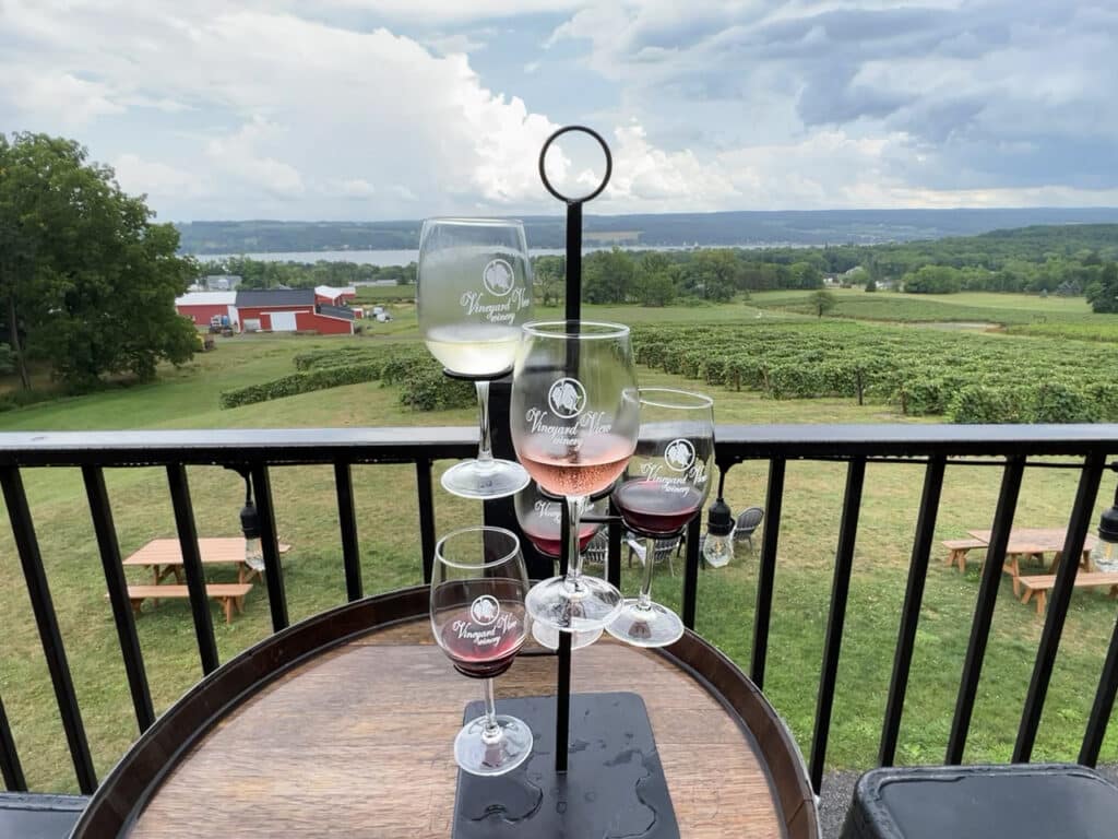 A tower of five wine samples overlooking a vineyard at Vineyard View Winery in the Finger Lakes, NY.