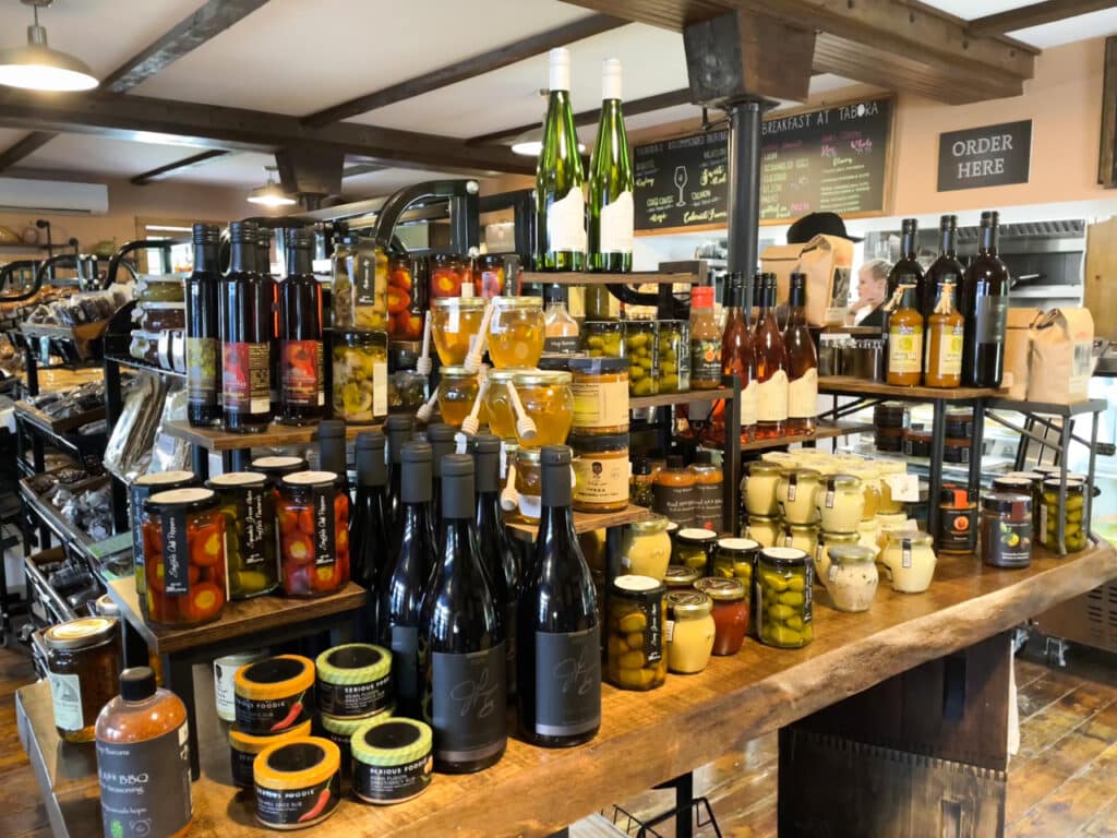 Shelves of wine and jarred foods inside a gourmet market. 