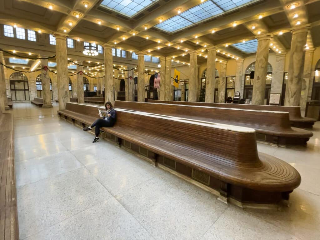 A woman sitting on a bench inside Union Station in downtown Utica, NY.