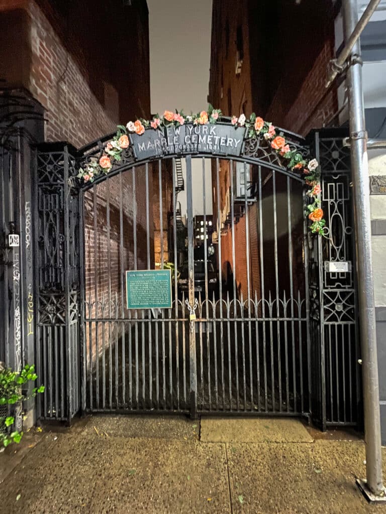 A closed iron gate at the entrance to New York Marble Cemetery in New York City.