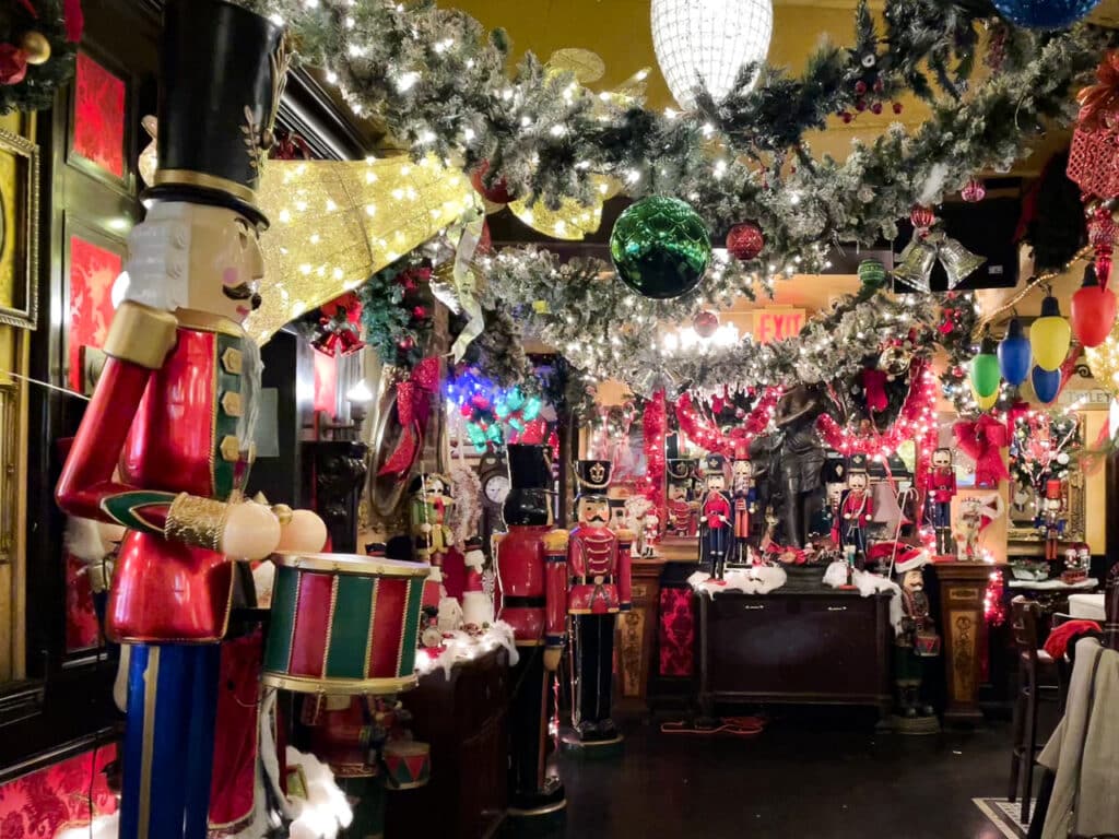 Christmas ornaments, garland, and nutcrackers decorate a restaurant in New York City.