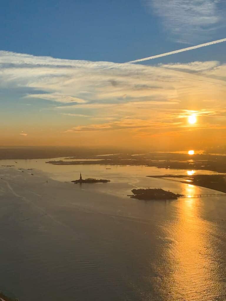 View of the Statue of Liberty at sunset from One World Observatory in New York City.