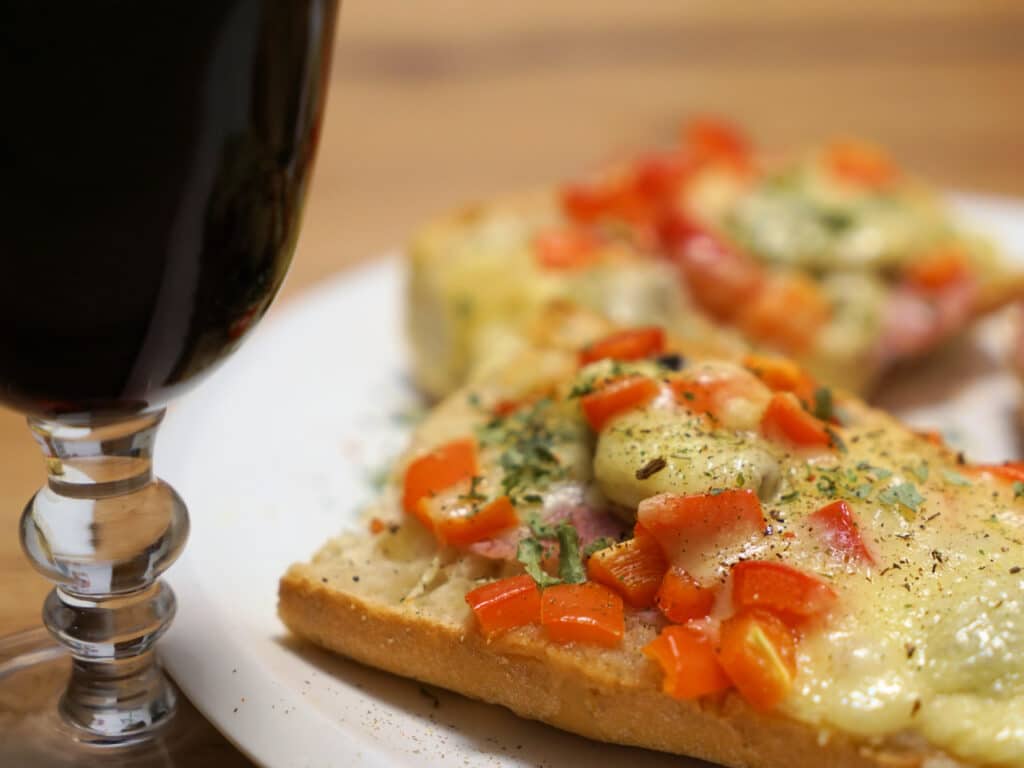 Bruschetta (toasted bread topped with tomatoes, cheese, and spices) and a glass of red wine. 